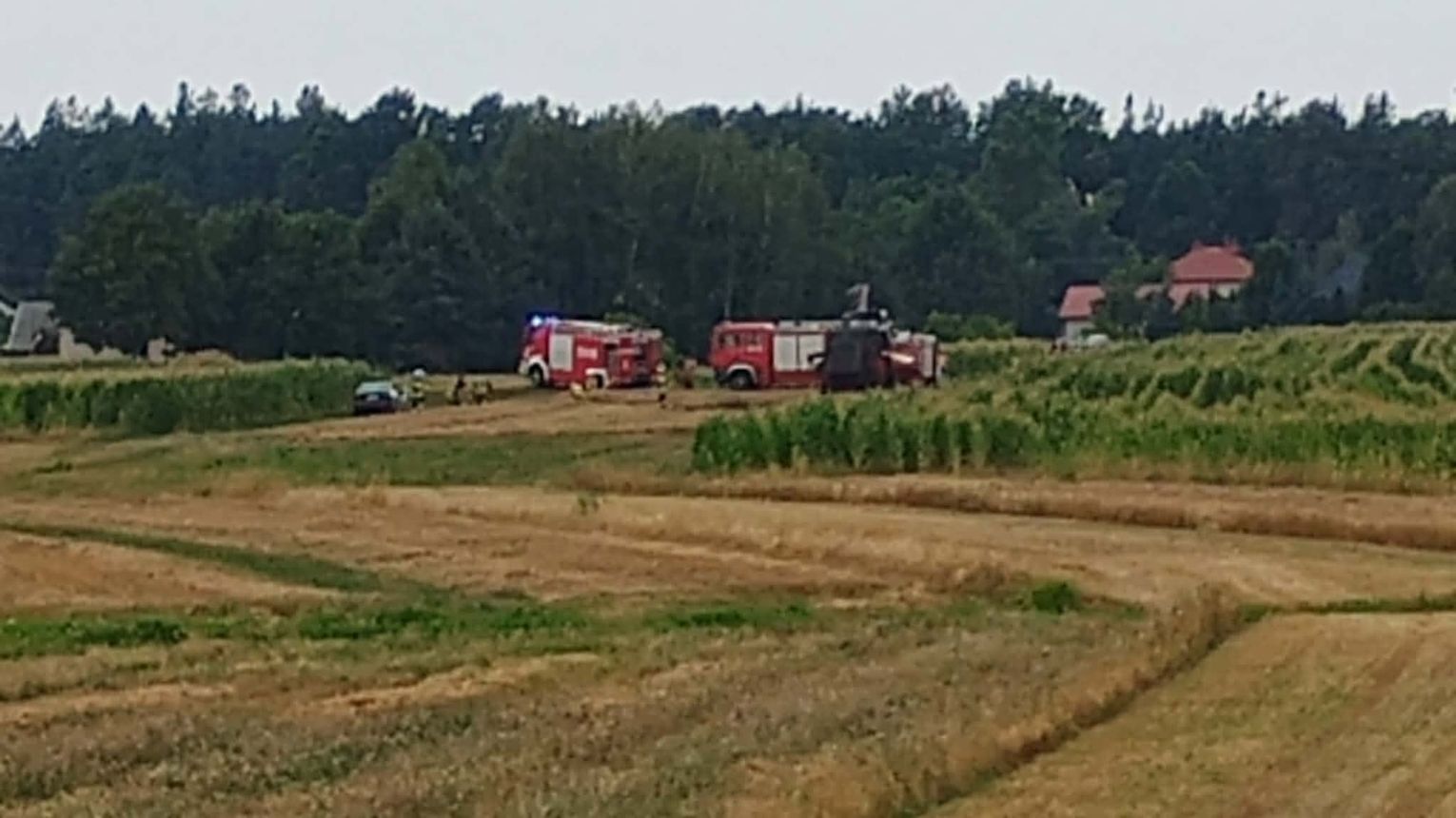Pożar kombajnu w Ławnicy. Duże zadymienie, strażacy pracują w aparatach ochronnych