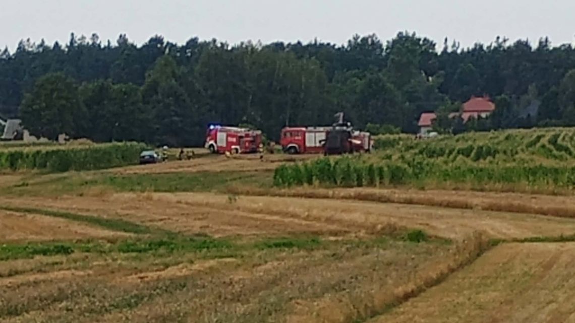 Pożar kombajnu w Ławnicy. Duże zadymienie, strażacy pracują w aparatach ochronnych